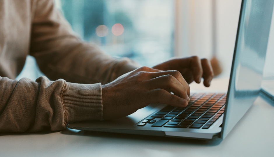 hands typing on a laptop